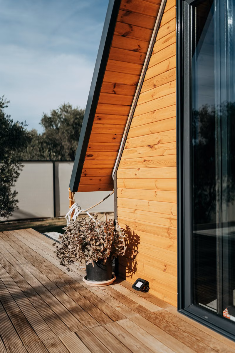 Pressure washing technician carefully cleaning a residential wooden deck