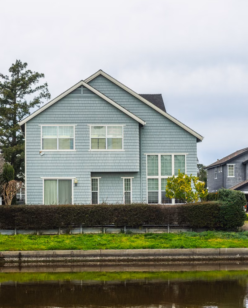 Professional cleaner washing the exterior siding of a suburban Charlotte home